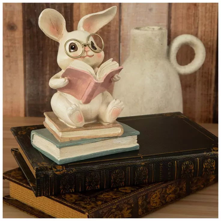 Figura de conejo sentado sobre libros