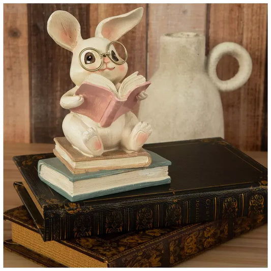 Figura de conejo sentado sobre libros